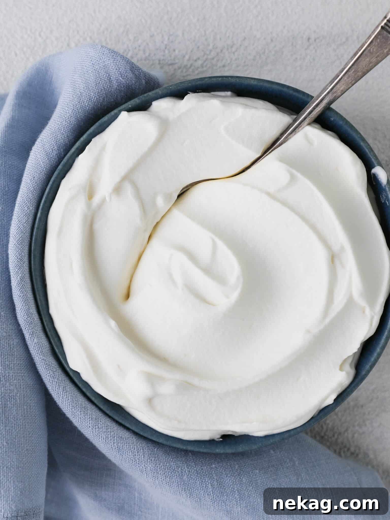 Silky Homemade Whip 6 A serving of homemade whipped cream gracefully scooped with a vintage spoon.