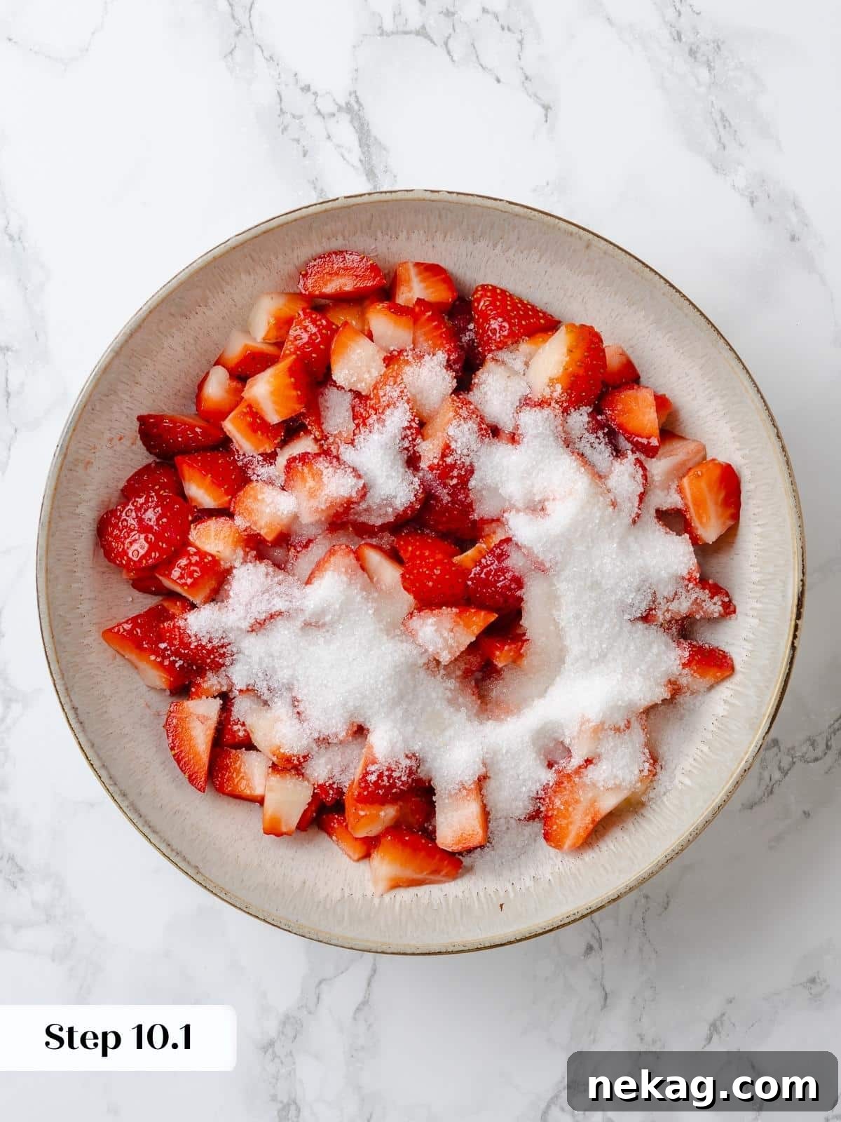 Freshly cut strawberries coated with sugar in a mixing bowl. Vibrant red, freshly cut strawberries are gently coated with granulated sugar and lemon juice in a mixing bowl, beginning the maceration process.