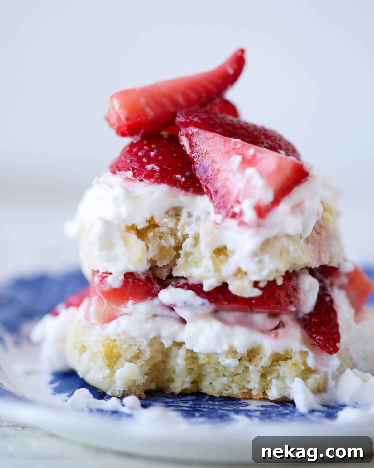 Strawberry Shortcake for Two cut open for Valentine's Day Desserts. A romantic individual strawberry shortcake, cut open to reveal layers of golden shortcake, ruby-red strawberries, and white whipped cream, perfect for a Valentine's Day treat or any special occasion.