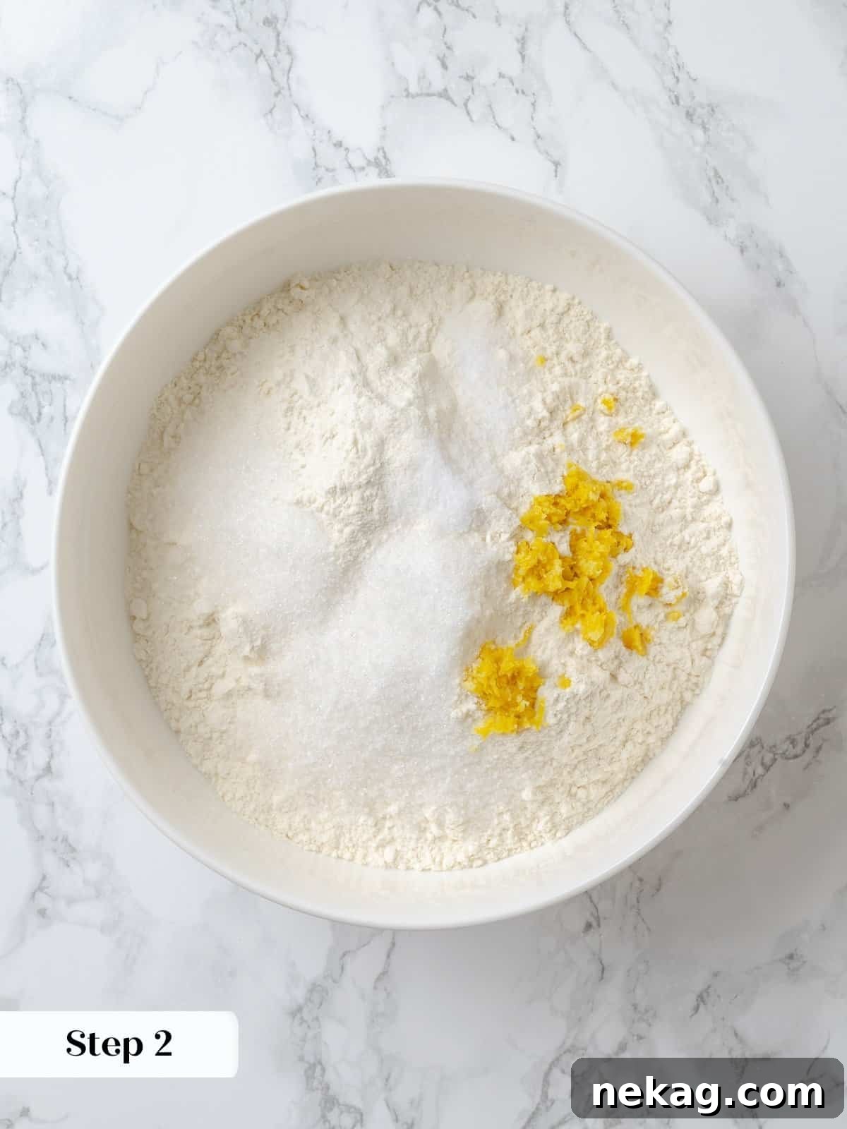 Blending dry ingredients evenly to prep for shortcake dough. A mixing bowl filled with whisked dry ingredients, a crucial first step in preparing the shortcake dough.