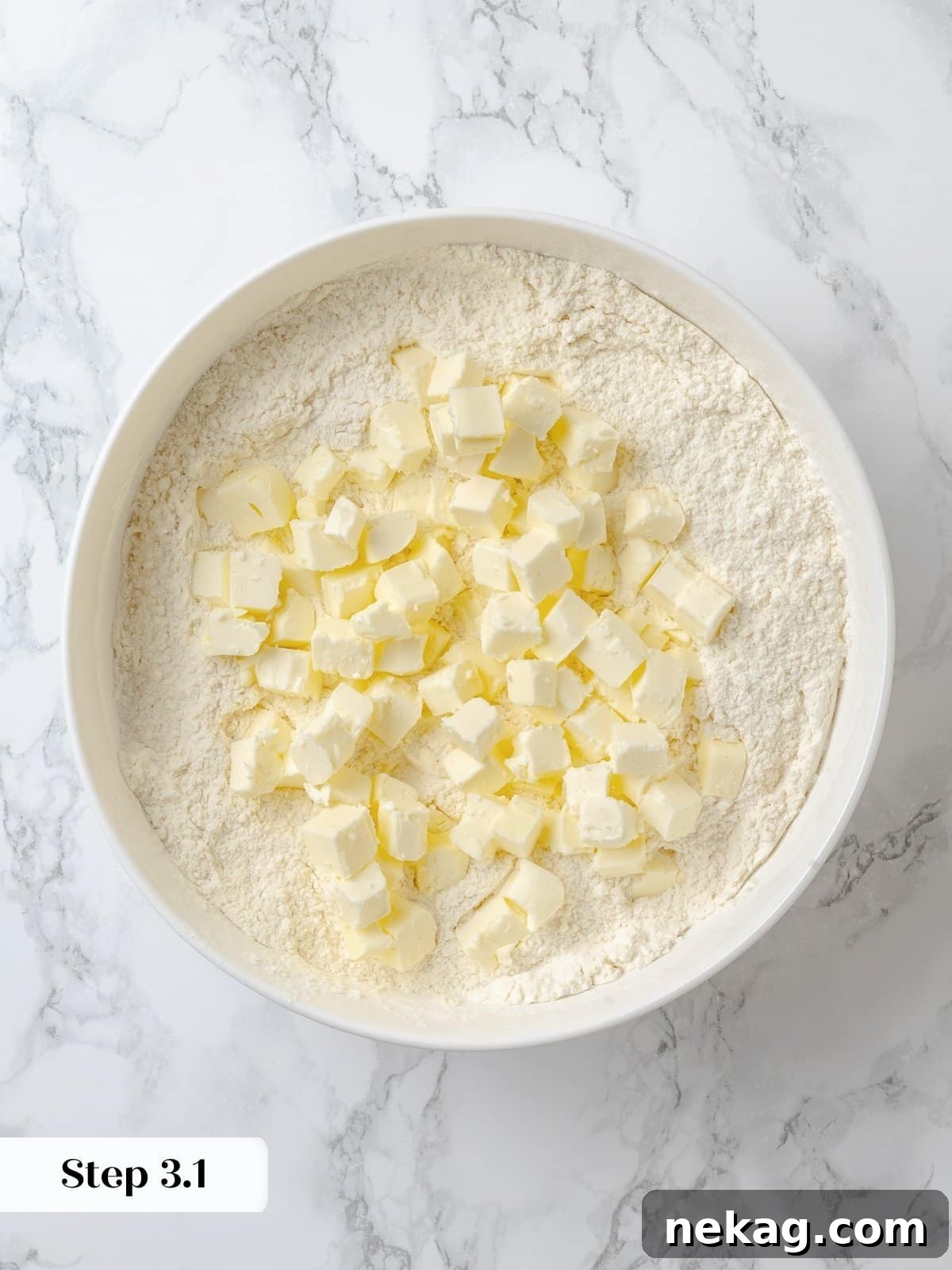 Incorporating cold butter into dry ingredients to start the shortcake dough. Hands gently working cold butter into a bowl of dry ingredients, demonstrating the crucial step of cutting butter into flour for a tender shortcake.