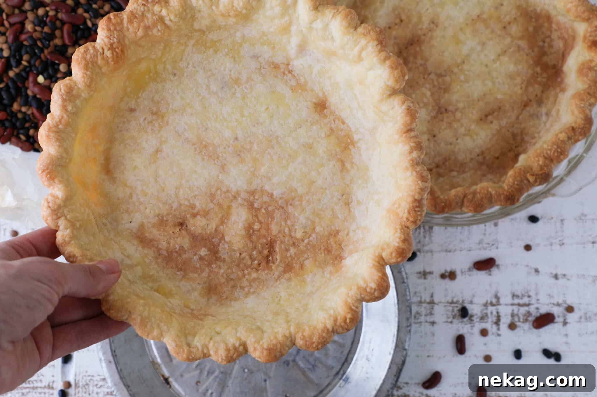 Flawless Crusts The Docking Dilemma Solved 7 A chef's hand holding a perfectly baked tart pastry, illustrating the quality achieved with proper docking and blind baking techniques.