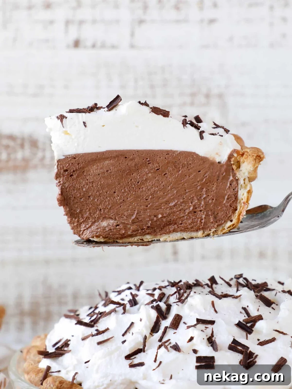 Silken Chocolate Indulgence 2 A slice of French Silk Pie on a plate with a pie server ready for serving, highlighting its light and airy texture.