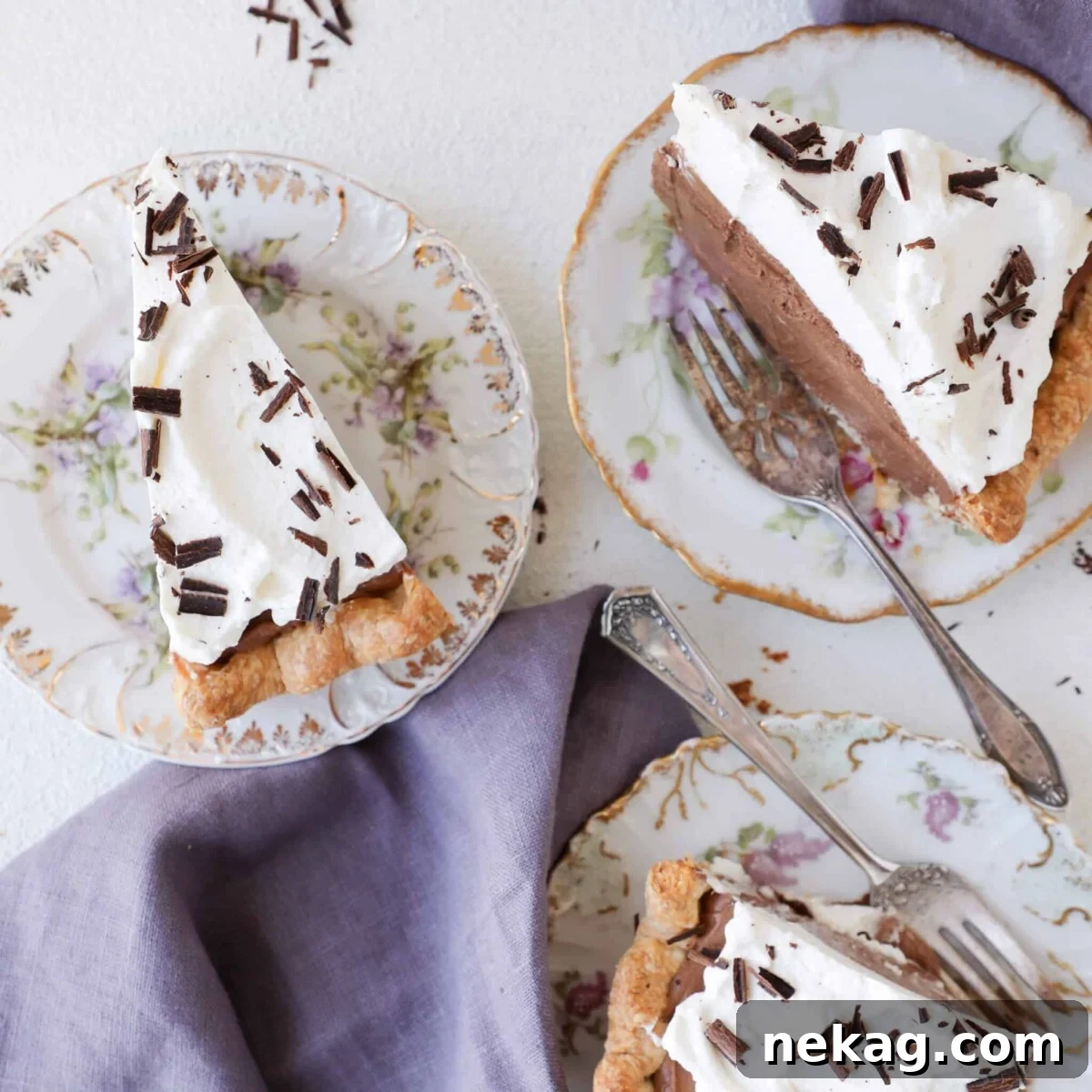 Silken Chocolate Indulgence 3 Three slices of French Silk Pie served on white plates with a clean white background, showcasing the perfectly set filling and elegant whipped cream swirls.