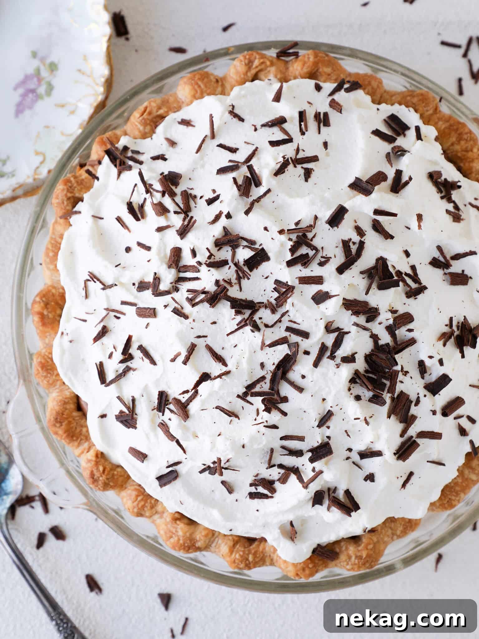 Silken Chocolate Indulgence 4 An overhead shot of a whole French Silk Pie, beautifully decorated with whipped cream swirls and chocolate shavings, ready for serving.