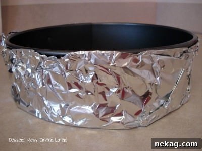 Perfect Gingersnap Pumpkin Cheesecake Minus The Cracks 2 Close-up of a springform pan double-wrapped in heavy-duty foil, a crucial step for a water bath cheesecake.