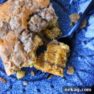 A delicious forkful of Pumpkin Crumb Coffee Cake, highlighting its moist texture.