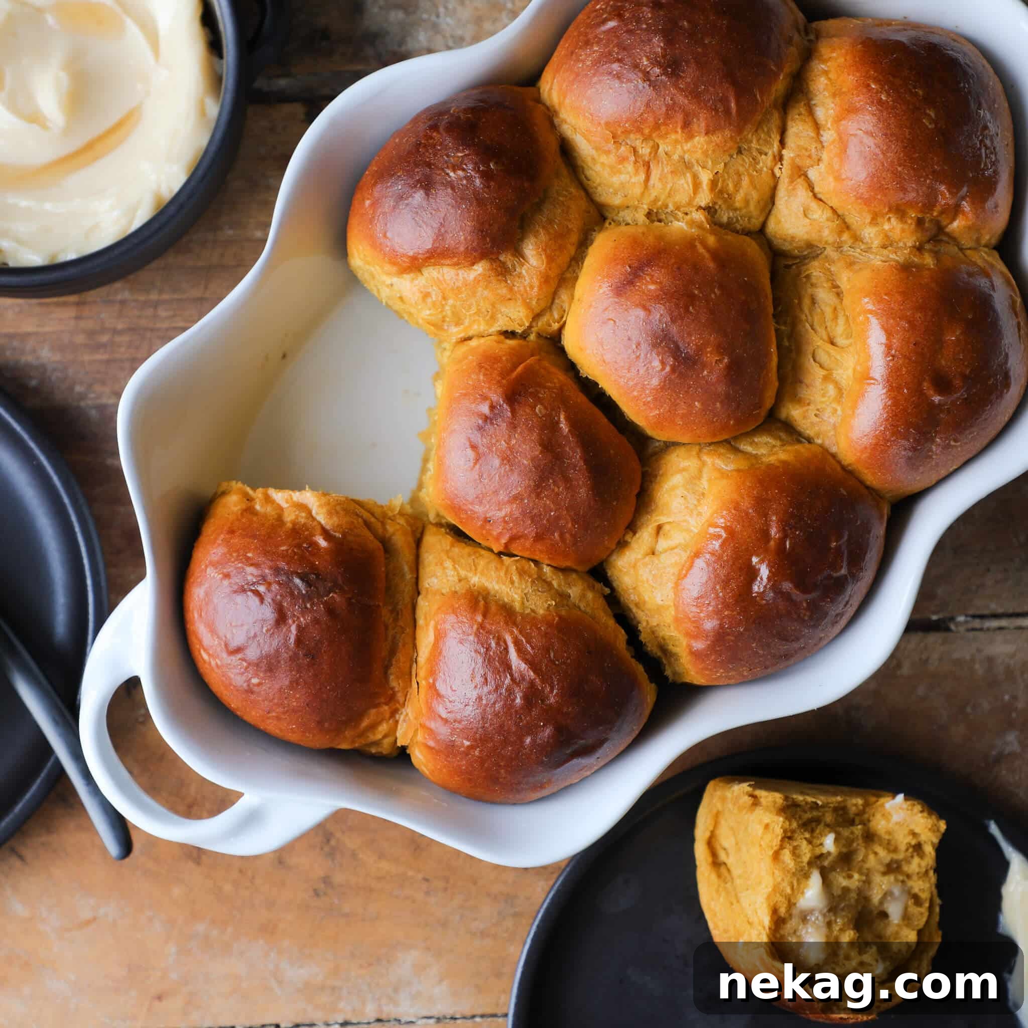 Savory Pumpkin Spice Dinner Rolls arranged on a rustic wood and slate background.