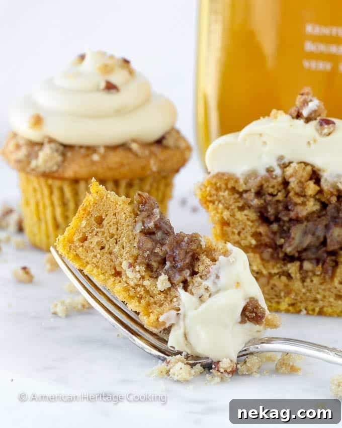 A Pumpkin Pecan Pie Cupcake, sliced open on a fork against a white background.