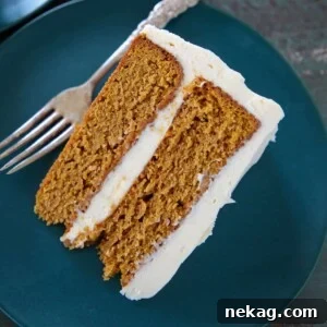 A perfectly cut slice of Pumpkin Spice Layer Cake on a plate.