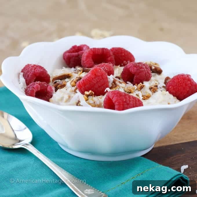 A close-up shot of Bircher Muesli in a clear glass, showing the soaked oats and grated apple