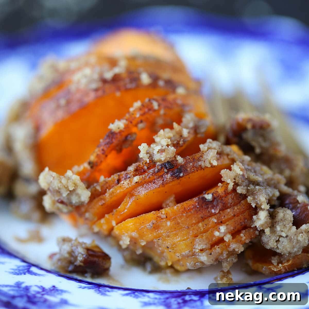Close-up of golden Hasselback Sweet Potatoes with pecan topping, showing the perfect texture.