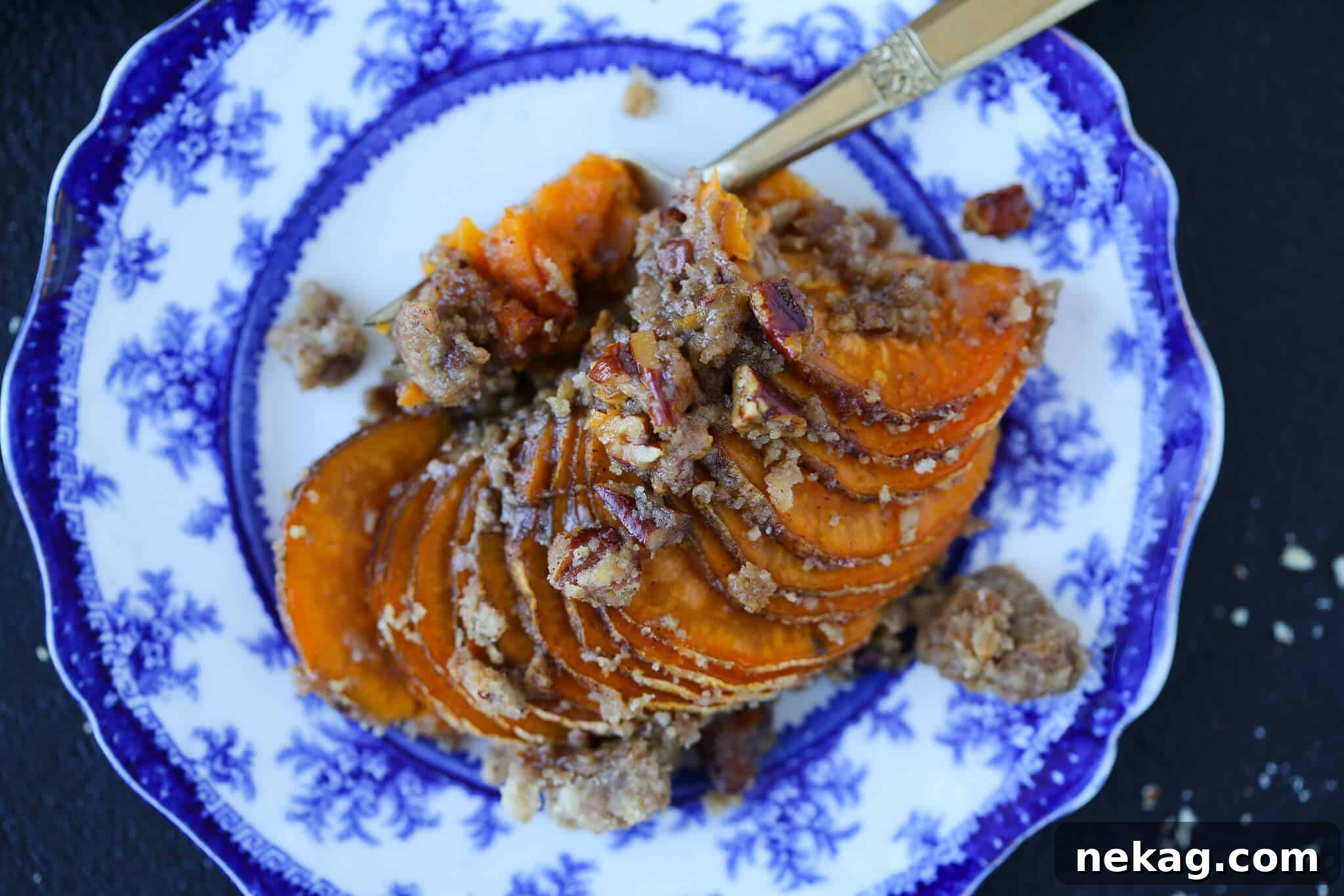 Hasselback Sweet Potato Casserole served on a blue and white plate, ready to enjoy.