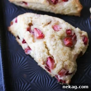 A single Strawberry Lemon Scone on a baking sheet, showcasing its perfect form and texture.