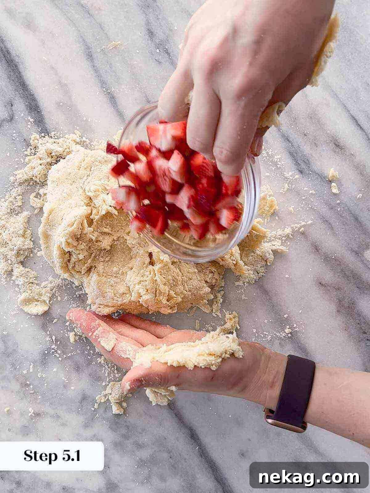 Homemade Strawberry Scones 7 Scone dough being gently kneaded on a floured surface, showing shaggy texture coming together.