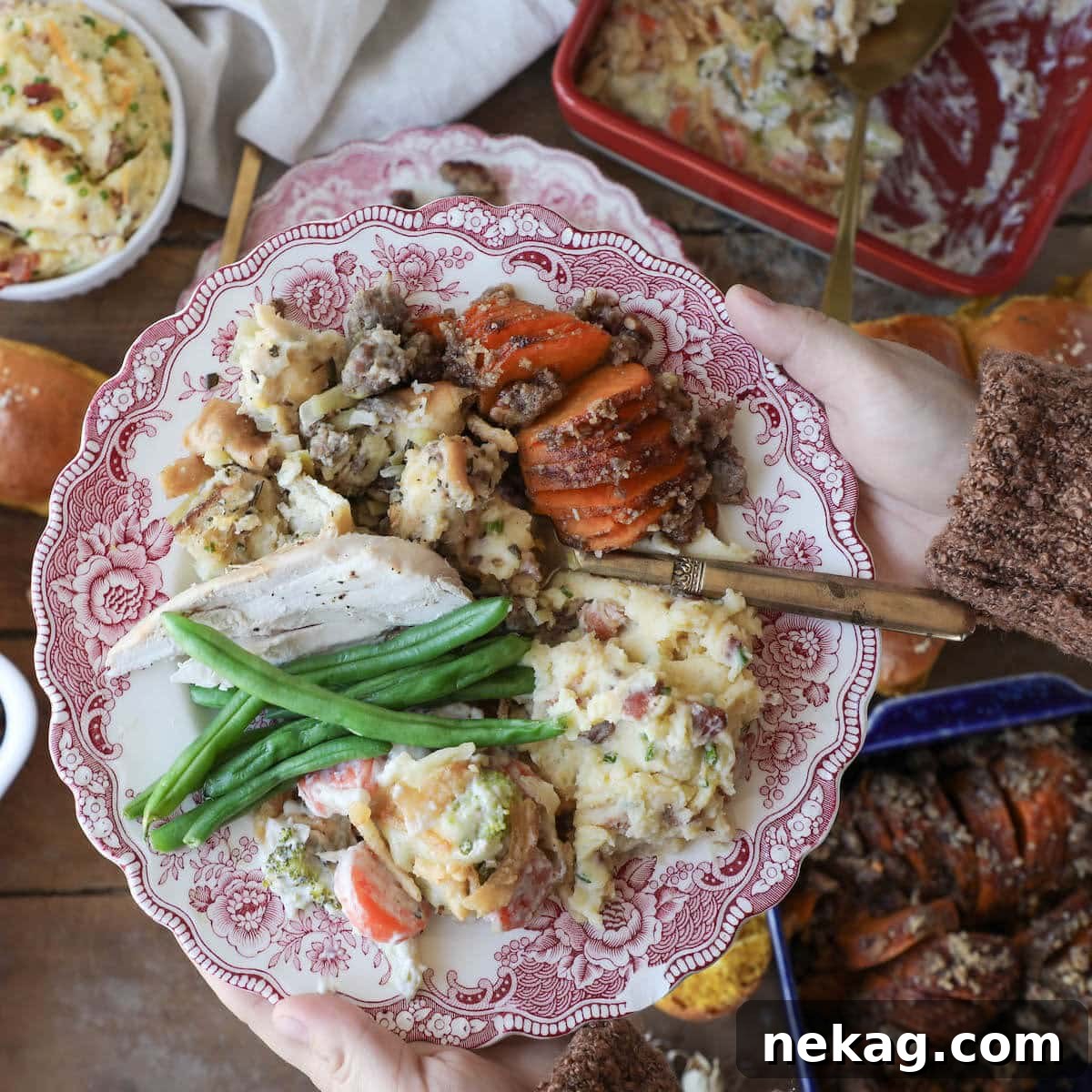 A hand holds a plate brimming with a selection of delicious Thanksgiving side dishes, ready for enjoyment.