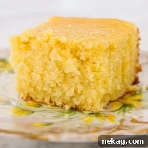 A slice of sweet cornbread presented on a vintage plate, adorned with yellow flowers.