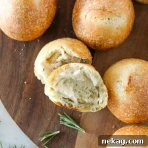 Rosemary Sourdough Rolls displayed in a rustic wooden tray.