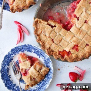 A round image of a Strawberry Rhubarb Pie in an almond lattice crust, featured.