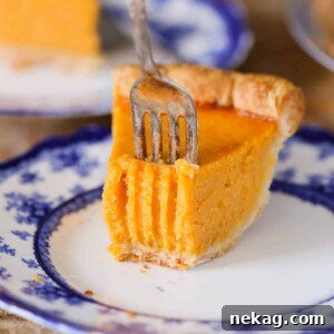 A round image of Mary Randolph's Sweet Potato Pie, one slice with a fork close up.