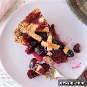 A close-up of a Cherry Pie slice with a beautiful lattice top, perfect for Thanksgiving.