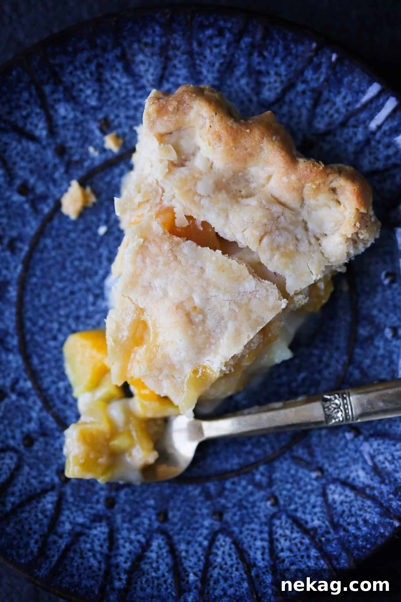 A delicious slice of Old Fashioned Peach Pie, a cherished addition to any Thanksgiving dessert spread.