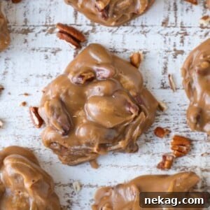A decadent brown pecan praline on a brown slate board amid a group of pralines.