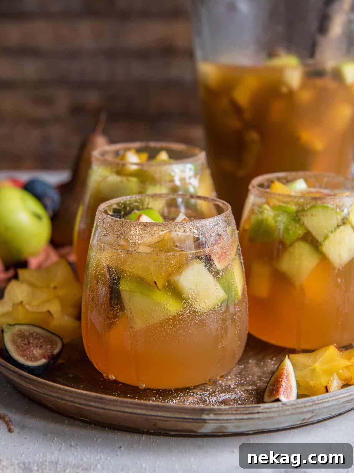 Elegant pear, apple, fig, and starfruit white wine sangria served in glasses, ready for a fall gathering.