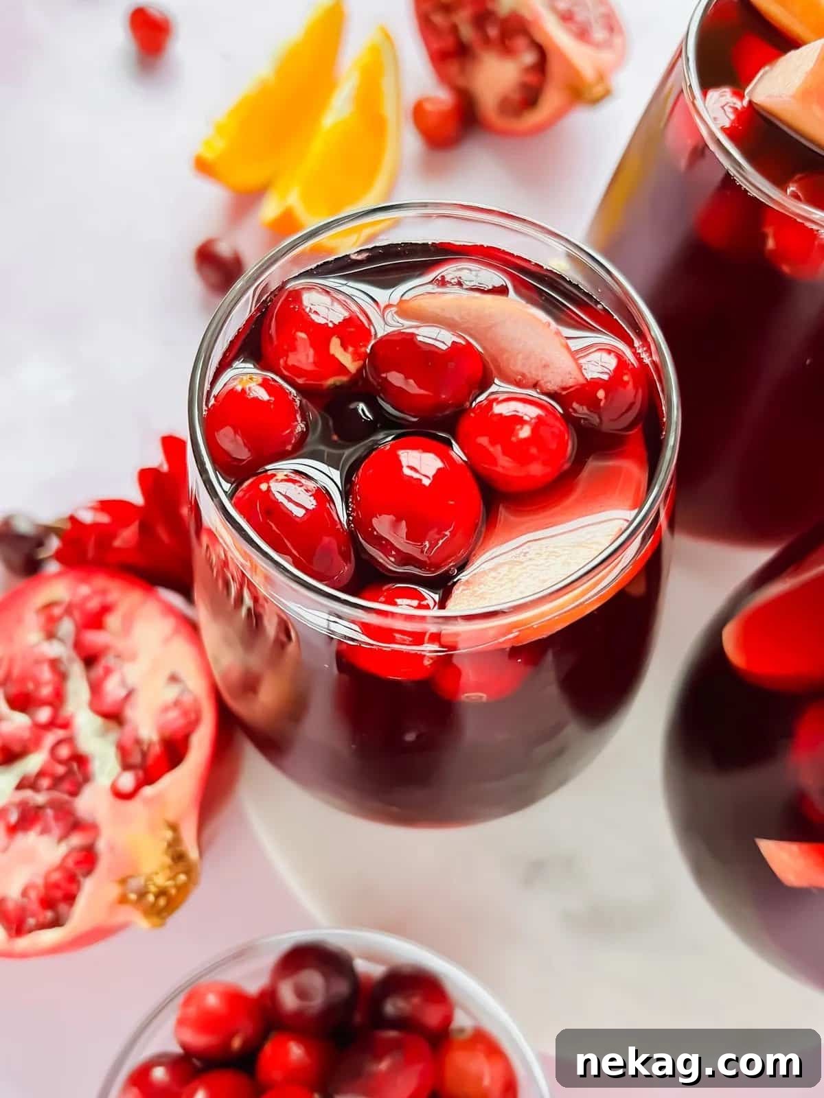 Bright red pomegranate cranberry sangria in an elegant glass, ready to serve.