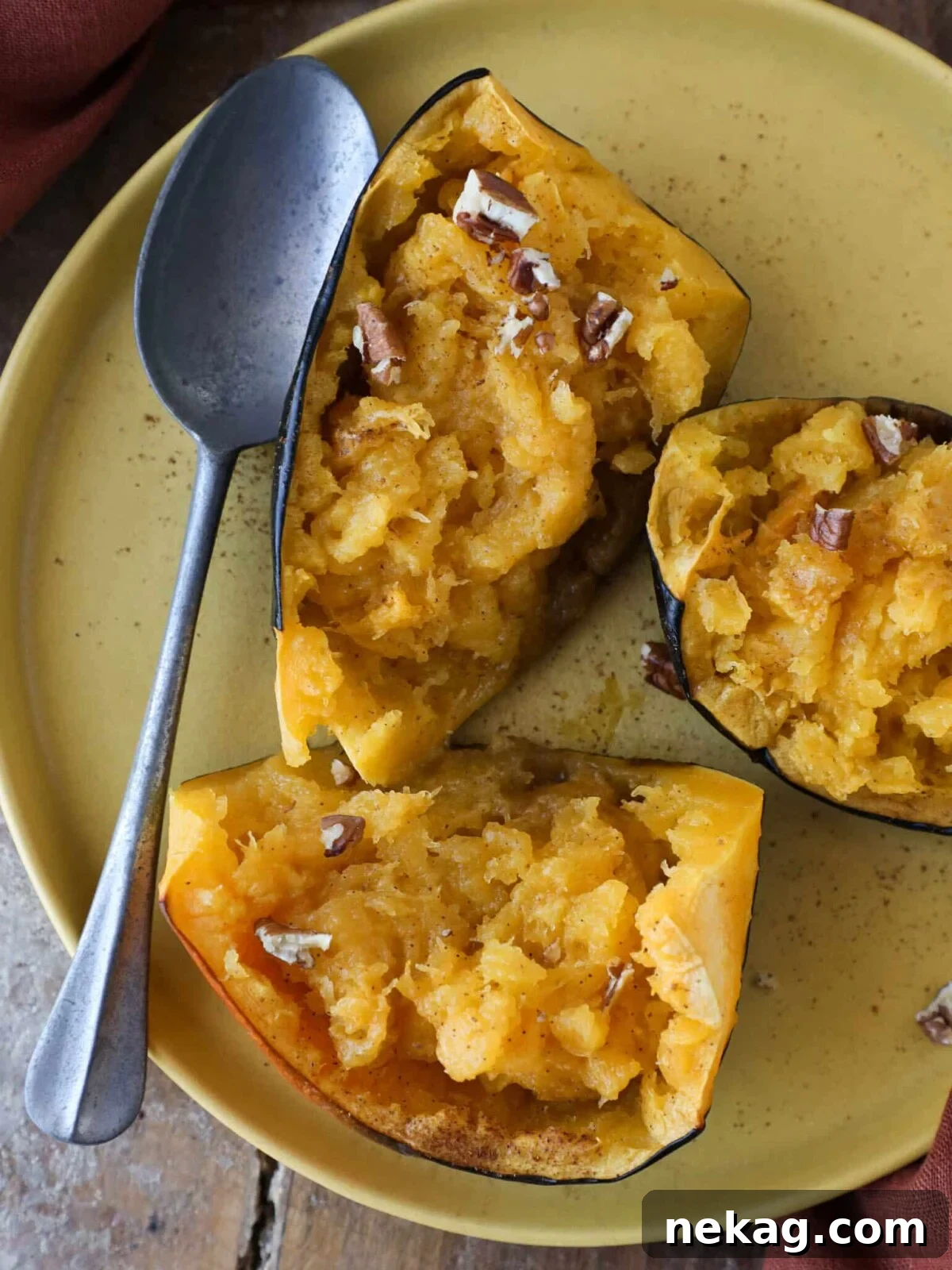 Brown Sugar Baked Acorn Squash served with a silver spoon, highlighting its tender texture.