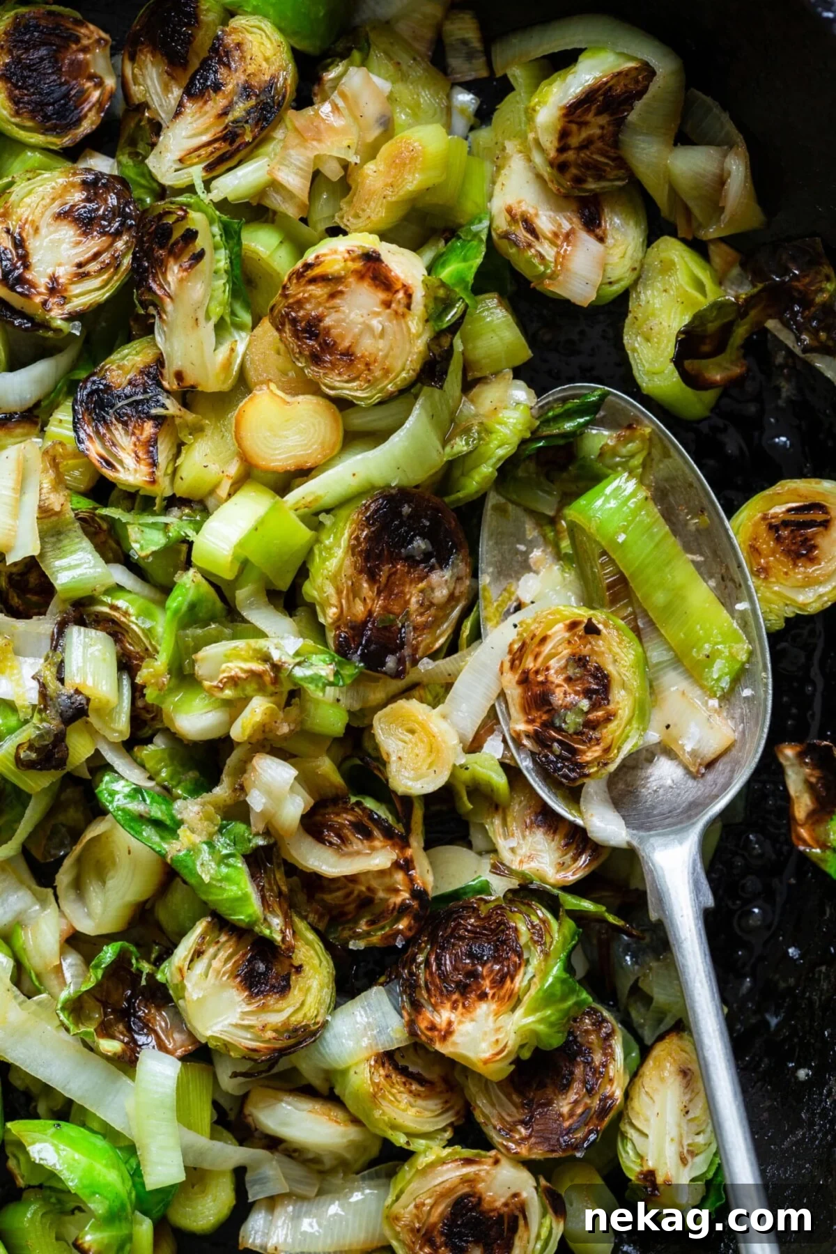 Close-up of Brussels Sprouts and Leeks with Lime Ginger Butter on a spoon, showcasing the delicious glaze.