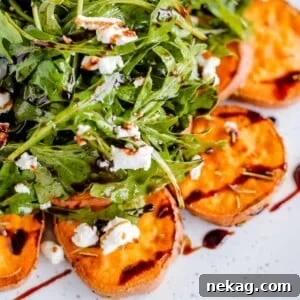 Green salad with sweet potatoes on white plate.