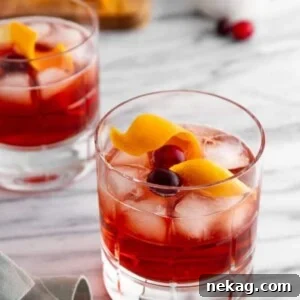 A holiday negroni on a marble countertop, garnished.