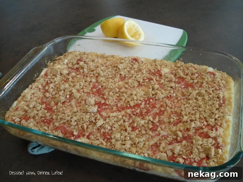 Sunny Strawberry Lemon Bars 4 Hand reaching for a perfectly chilled Strawberry Lemonade Square, highlighting its appealing texture