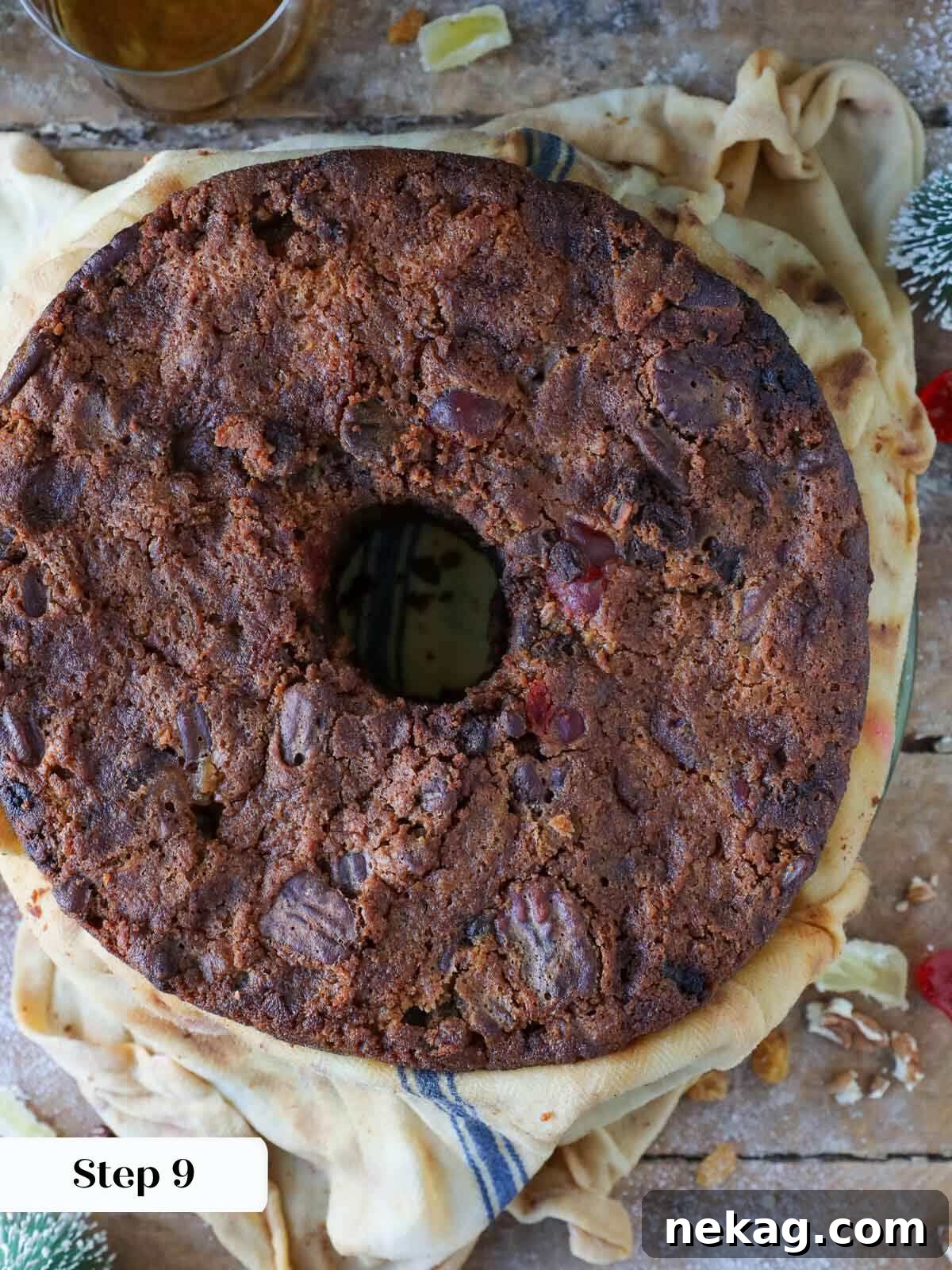 Baked fruit cake unwrapped from a brandy-soaked towel, showing its moist texture.