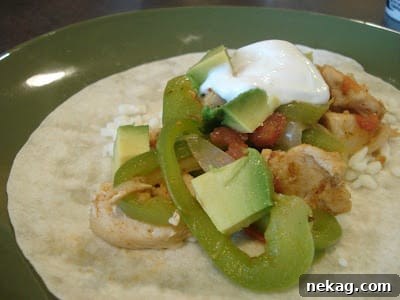 One-Pan Zesty Chicken Fajitas 4 Close-up of cooked skillet chicken fajitas with visible chicken, bell peppers, and onions, served on a plate
