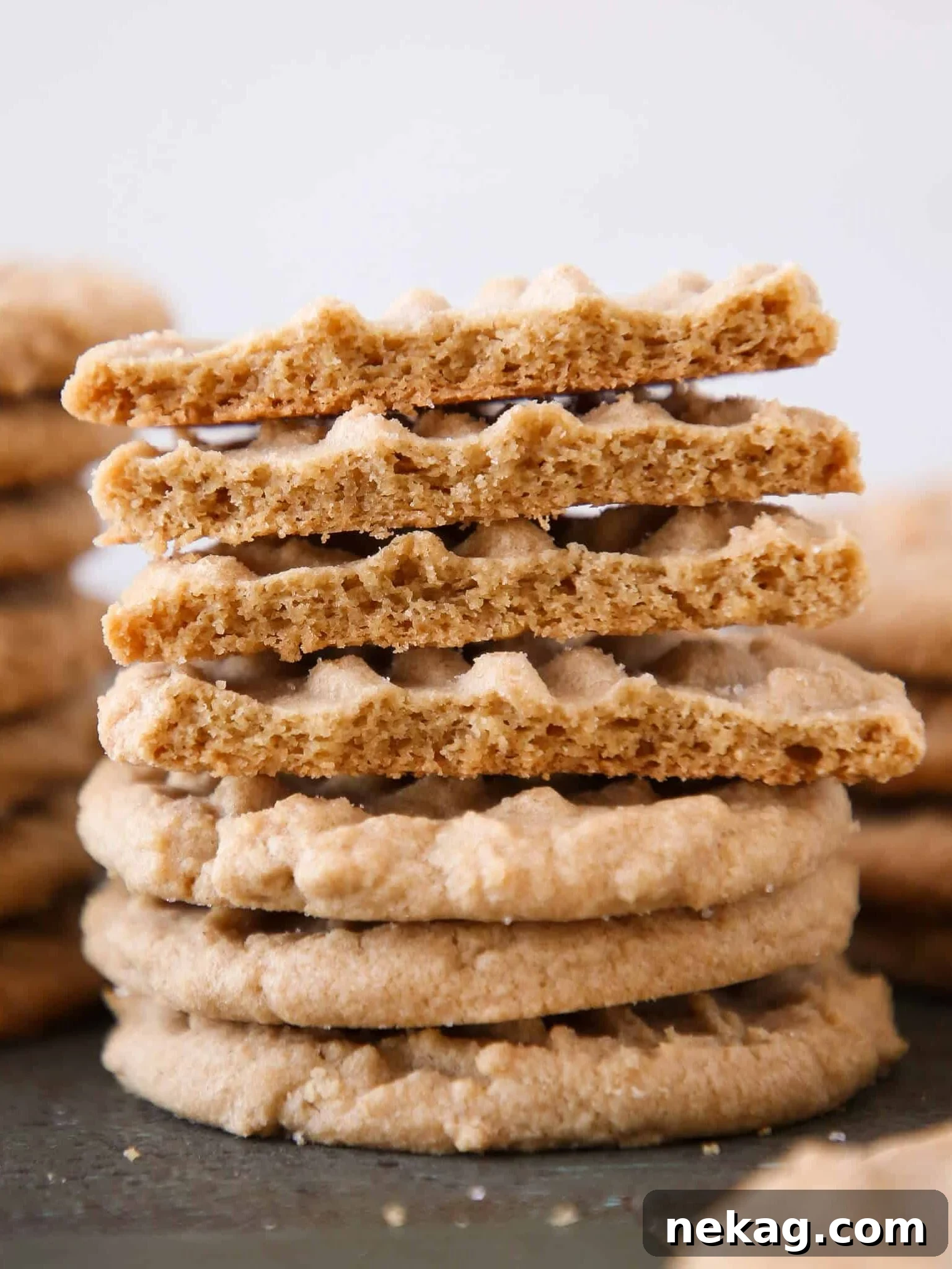 Old fashioned peanut butter cookies stacked with the top few broken open, showcasing their perfect texture.