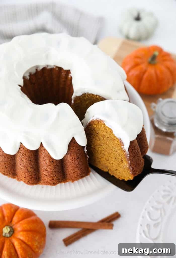 Spiced Pumpkin Crown 2 Cake server removing a slice of Pumpkin Bundt Cake with Cream Cheese Frosting