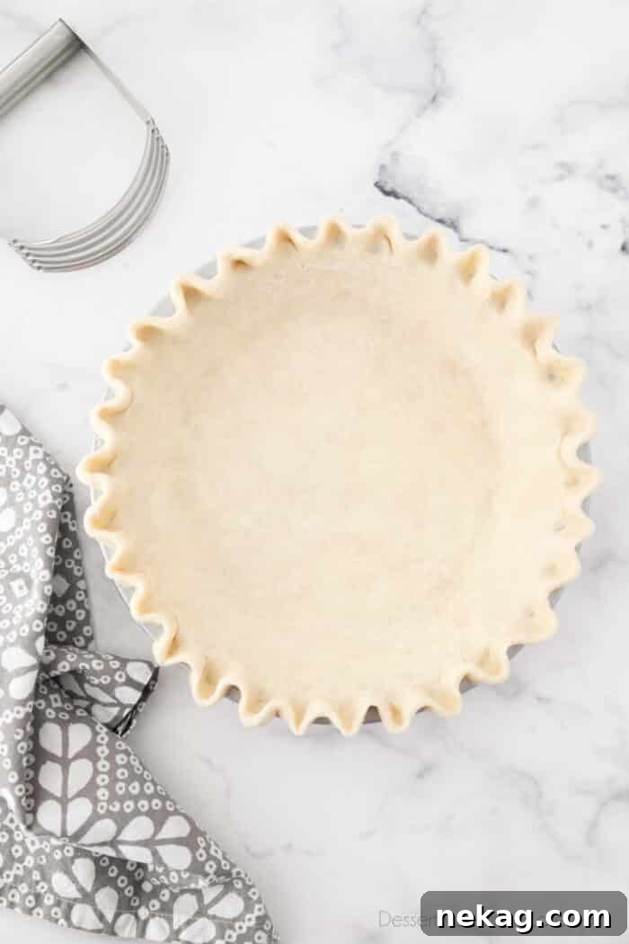 Flaky Butter Pie Crust 2 Perfectly crimped all-butter pie crust ready for filling in a pie pan.