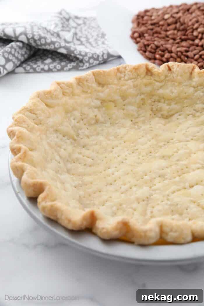 Perfecting Your Blind Baked Pie Crust 11 A captivating side view of a perfectly baked golden-brown pie crust nestled in its pan, showcasing its crisp, flaky texture and well-defined crimped edges.