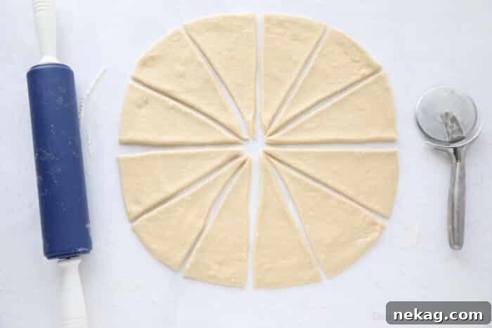 Perfect Homemade Crescent Rolls Video Recipe 10 A circular dough disc expertly rolled out and precisely cut into twelve triangular wedges, ready for shaping into crescent rolls.
