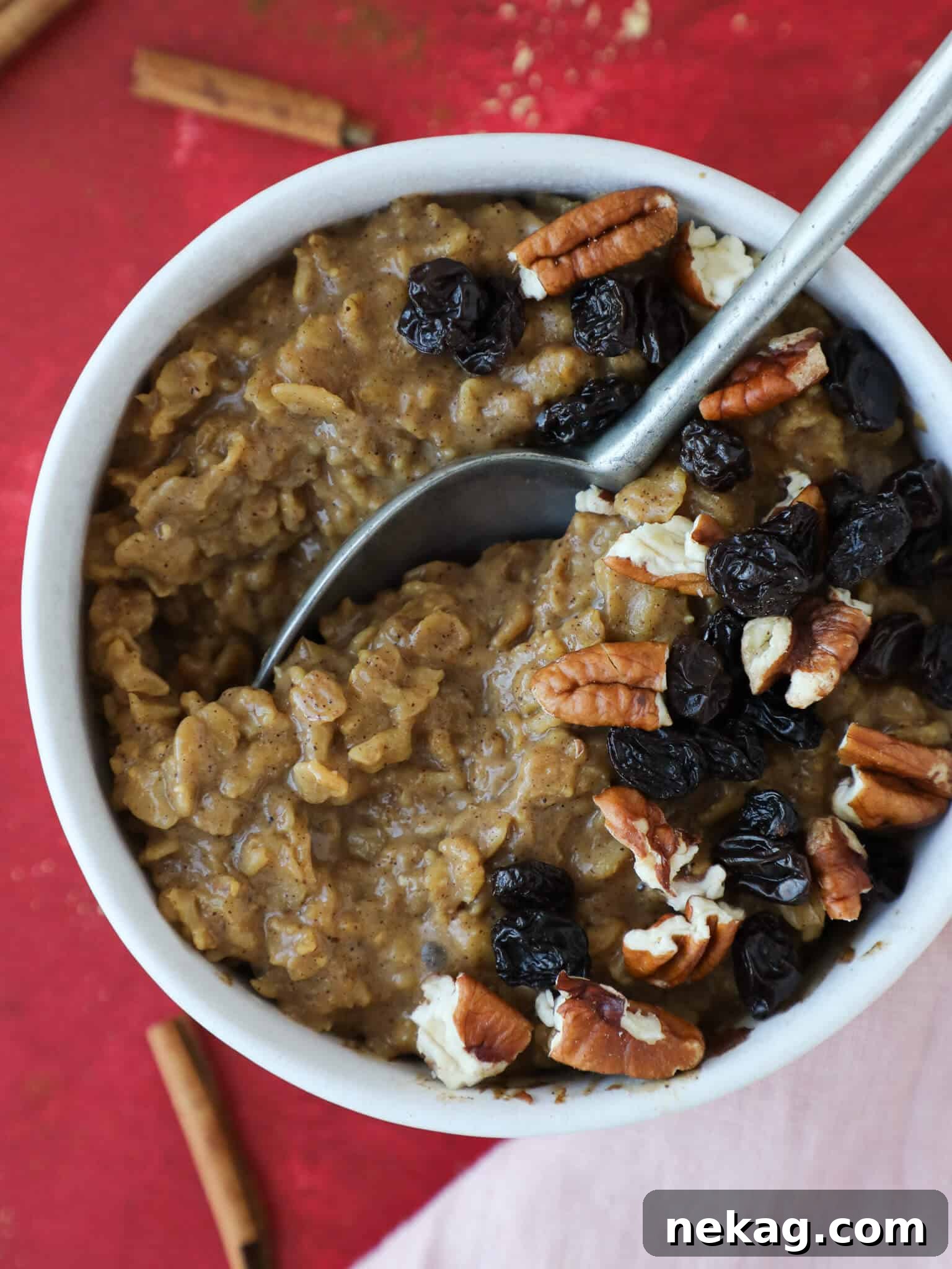 Spiced Gingerbread Oats 2 A bowl of gingerbread oatmeal topped with chopped pecans and a light drizzle, ready to be enjoyed.