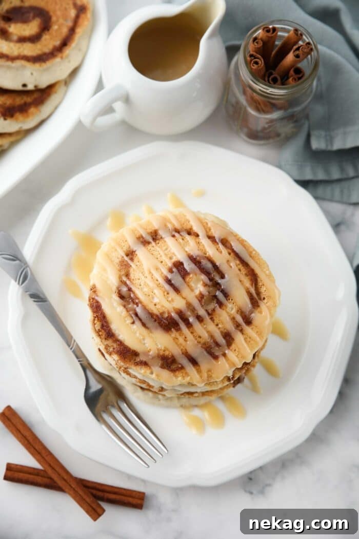 Swirled Cinnamon Pancake Stacks 9 Top view of cinnamon roll pancakes with cream cheese glaze drizzled on top.