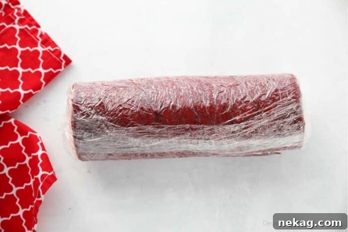 Mastering the Red Velvet Cake Roll 13 A Red Velvet Cake Roll wrapped tightly in plastic wrap, ready for chilling in the fridge or freezer.