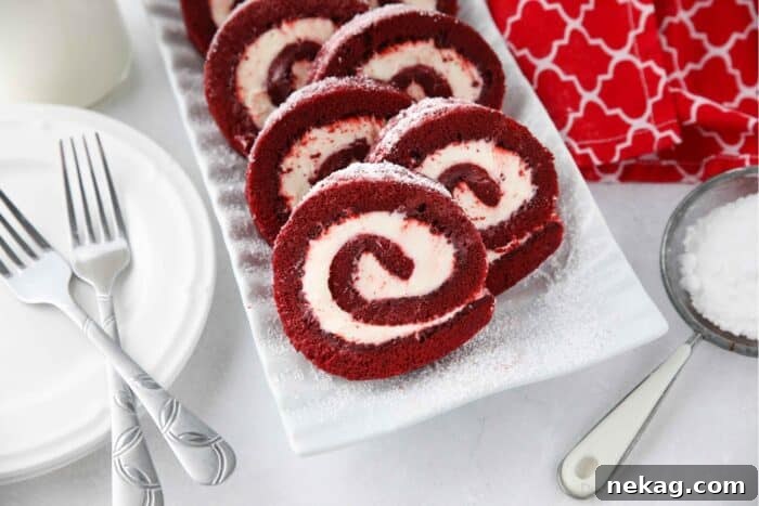 Mastering the Red Velvet Cake Roll 15 A beautifully sliced Red Velvet Cake Roulade arranged on a white serving plate, ready to be enjoyed.