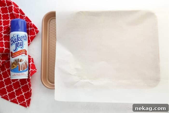 Mastering the Red Velvet Cake Roll 6 Jelly roll pan lined with parchment paper, next to a can of non-stick baking spray.