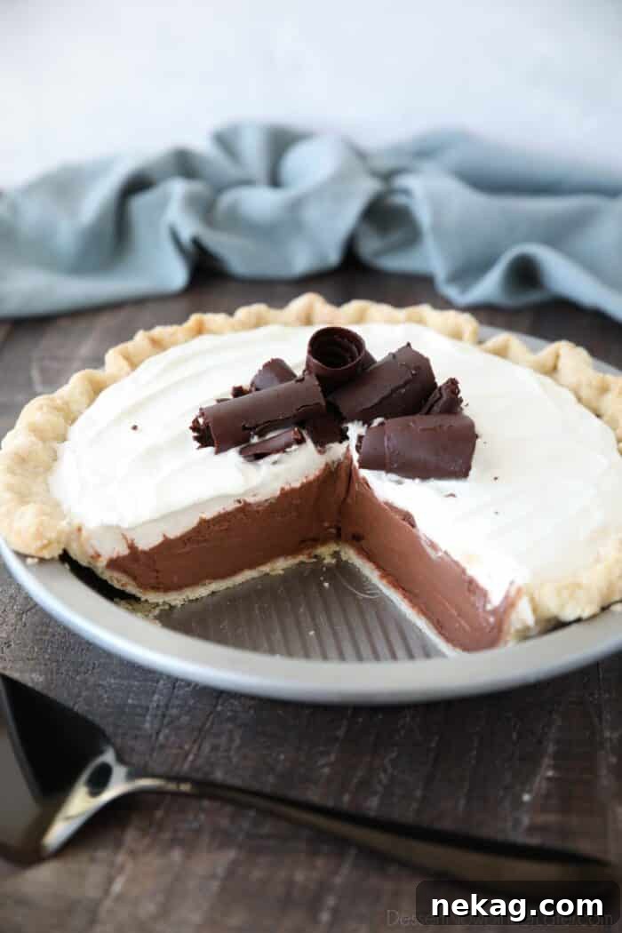Decadent Chocolate Cream Pie 2 Angled view of a delectable Chocolate Cream Pie with a couple slices elegantly removed, showcasing its layers.