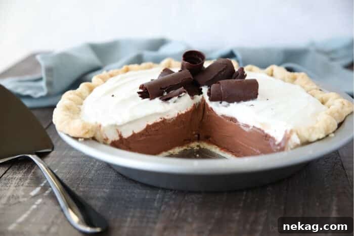 Decadent Chocolate Cream Pie 4 Side view of a beautifully prepared Chocolate Cream Pie, adorned with elegant chocolate curls on top, highlighting its perfect layers.