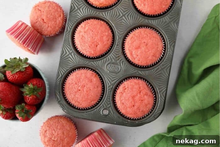 Baked strawberry cupcakes in a muffin pan.