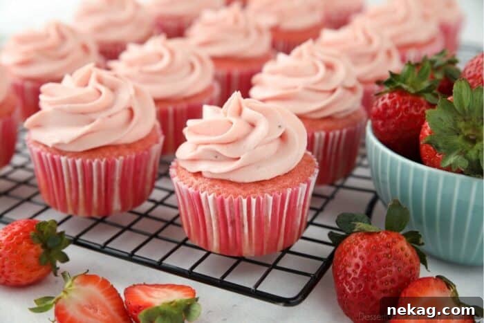 Frosted strawberry cupcakes on a wire cooling rack.